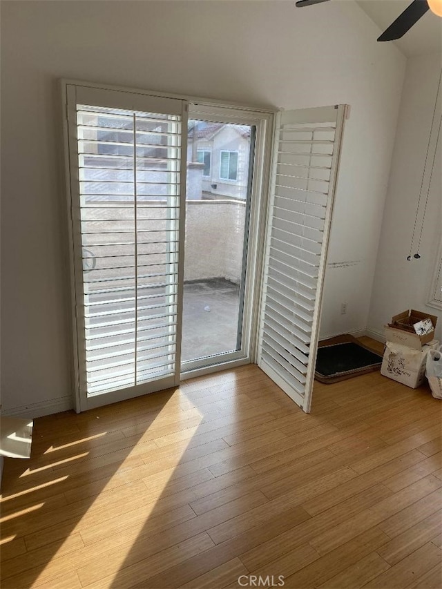 doorway to outside with ceiling fan, baseboards, and wood finished floors