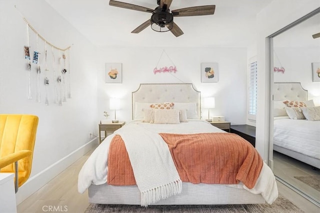 bedroom featuring ceiling fan, baseboards, and wood finished floors