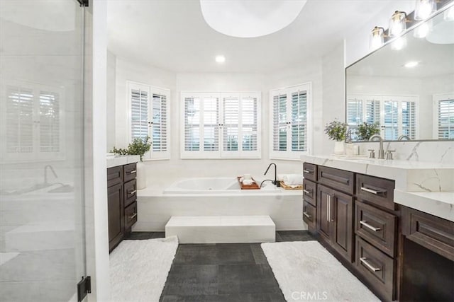 bathroom with a shower stall, vanity, and a bath