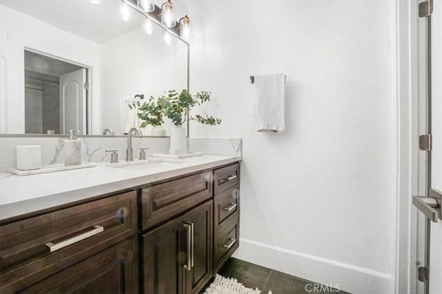 bathroom with tile patterned floors, vanity, and baseboards