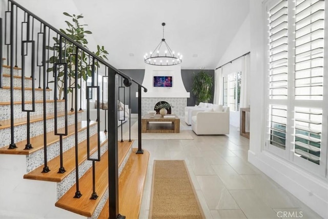 interior space with a chandelier, lofted ceiling, and stairway