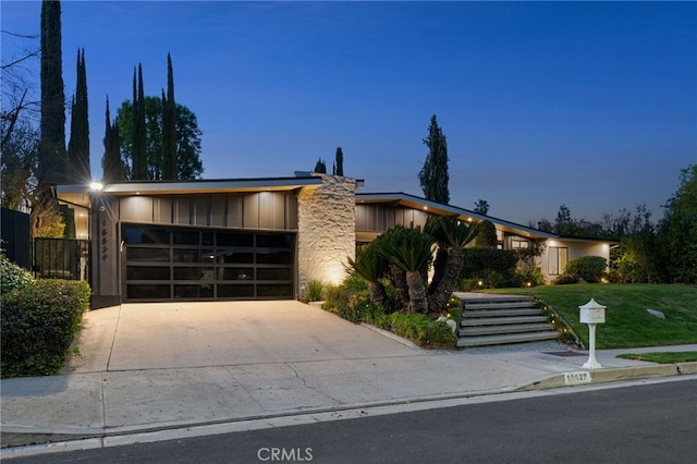 view of front of home with a garage, a front lawn, board and batten siding, and concrete driveway