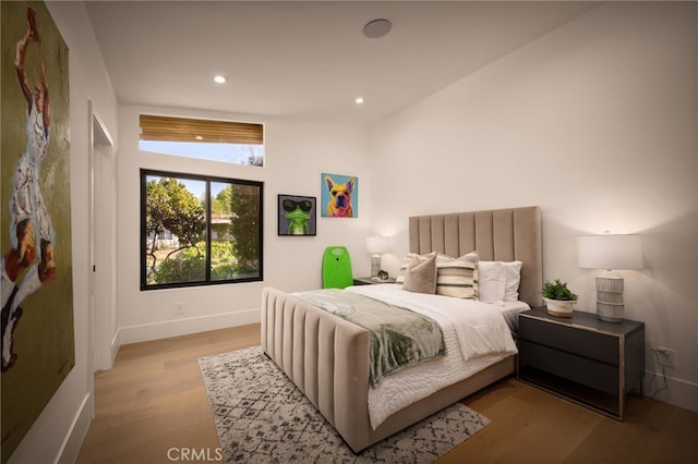 bedroom with baseboards, wood finished floors, and recessed lighting