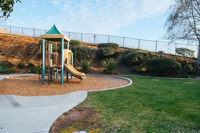 community jungle gym with fence and a yard