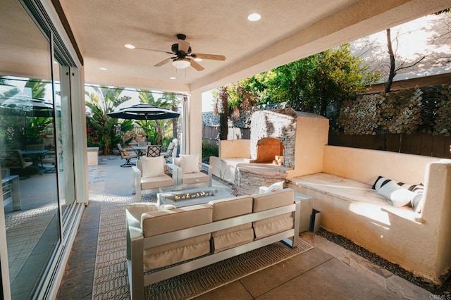 view of patio featuring outdoor dining space, ceiling fan, and an outdoor living space with a fire pit