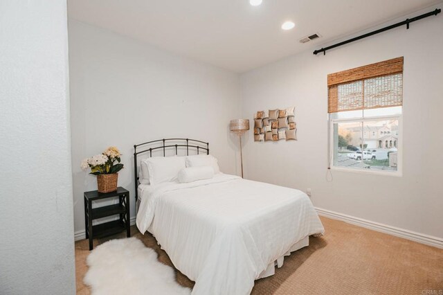 bedroom with light colored carpet, visible vents, baseboards, and recessed lighting