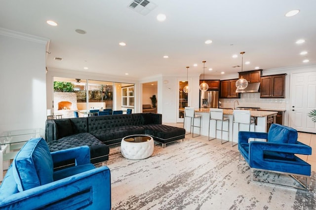 living room with visible vents, crown molding, and recessed lighting