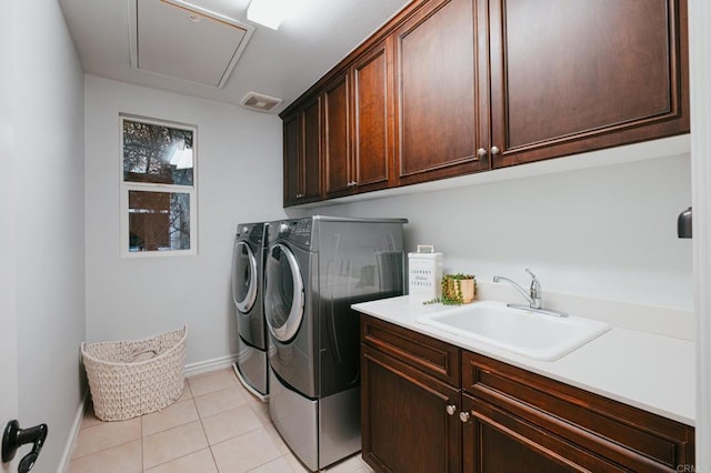 clothes washing area with washer and clothes dryer, light tile patterned floors, cabinet space, attic access, and a sink