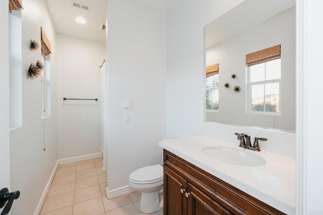 bathroom featuring visible vents, toilet, vanity, baseboards, and tile patterned floors