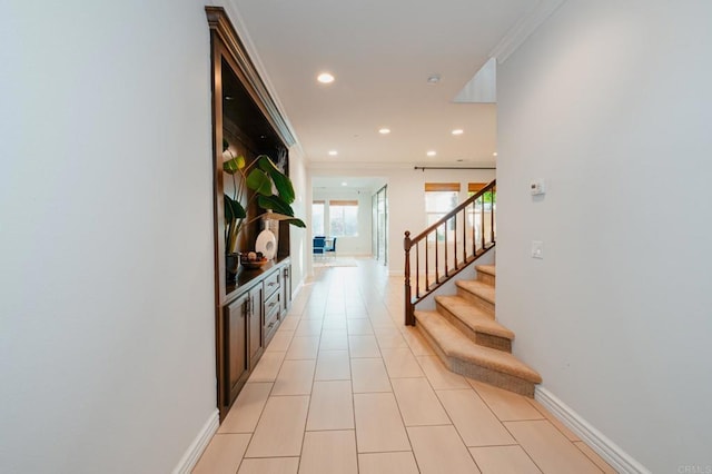 hall featuring crown molding, recessed lighting, light tile patterned flooring, baseboards, and stairs