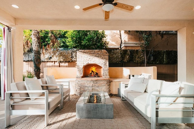 view of patio / terrace featuring a ceiling fan, fence, and an outdoor living space with a fireplace