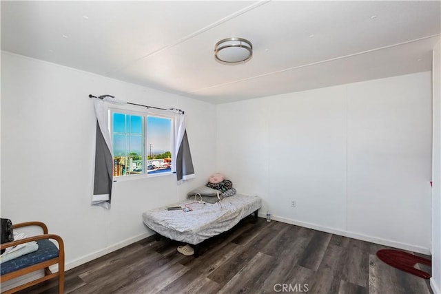 bedroom with wood finished floors and baseboards