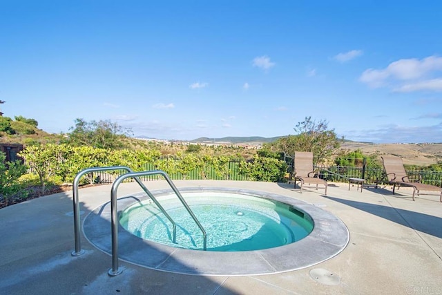 view of swimming pool featuring a patio, fence, and a hot tub