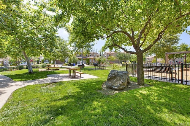 surrounding community with fence and a lawn