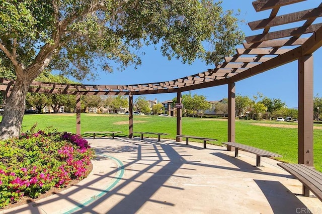 view of property's community featuring a lawn, a patio, and a pergola