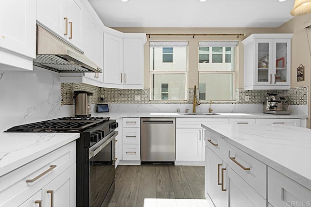 kitchen with stainless steel dishwasher, gas stove, white cabinetry, and under cabinet range hood