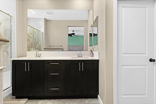 full bathroom featuring ceiling fan, double vanity, a stall shower, and a sink