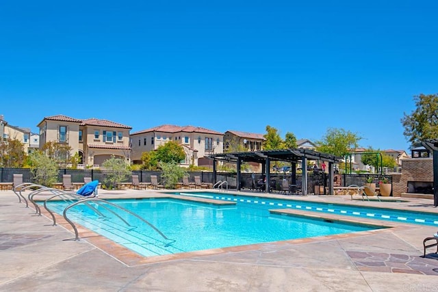 community pool with a patio area, a residential view, fence, and a pergola