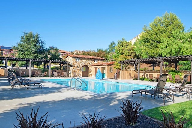 pool with a patio area, fence, and a pergola