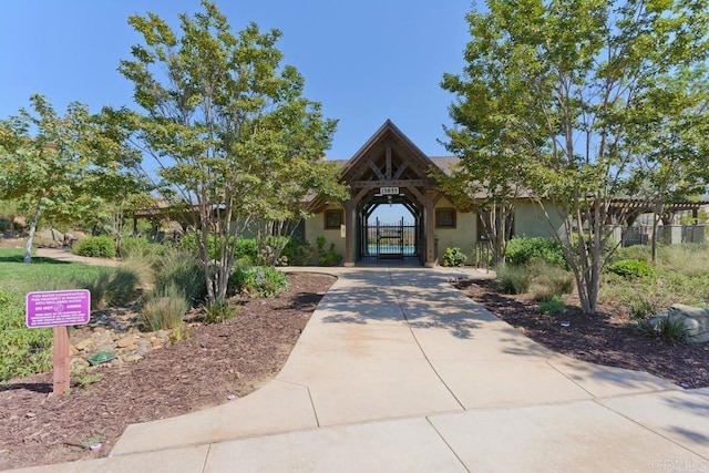 view of front of house featuring a gate, fence, and stucco siding