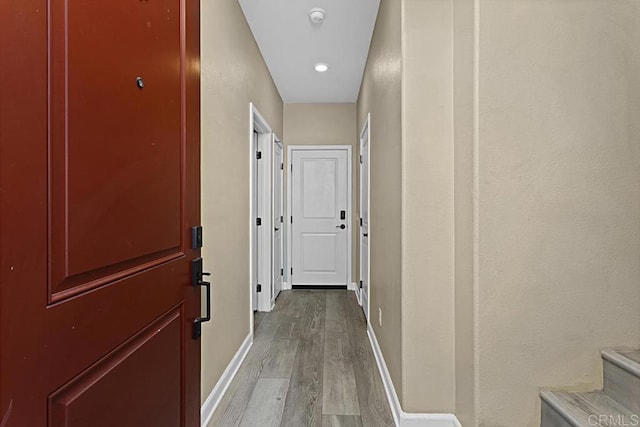 hallway featuring light wood-type flooring and baseboards