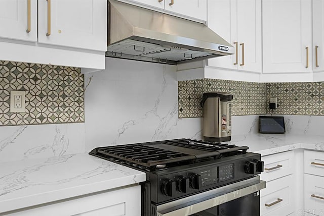 kitchen with decorative backsplash, white cabinets, black gas stove, light stone countertops, and under cabinet range hood