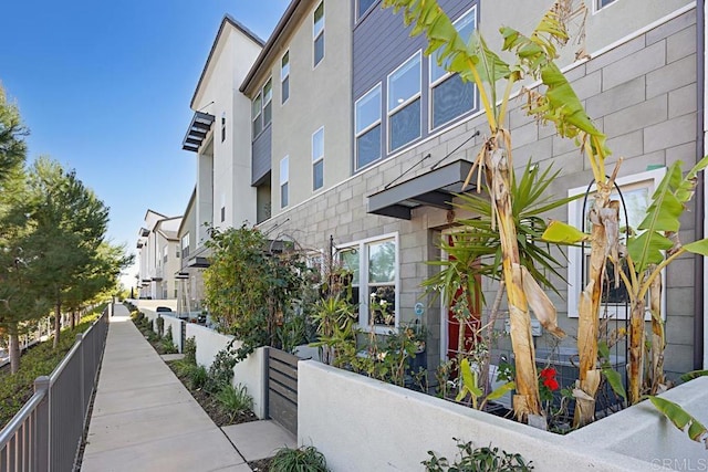 view of side of home with a residential view and fence