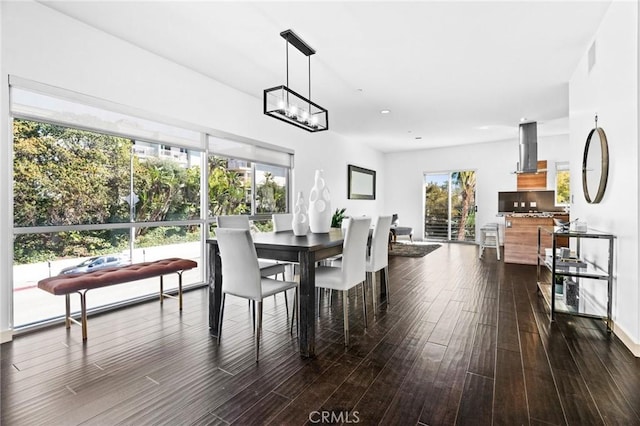 dining room with dark wood-style flooring and a chandelier