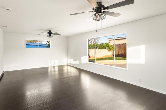 empty room featuring ceiling fan, wood finished floors, and a healthy amount of sunlight