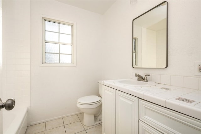 bathroom featuring toilet, tile patterned flooring, baseboards, and vanity