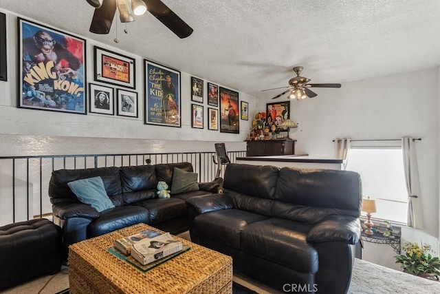 living area with a ceiling fan and a textured ceiling