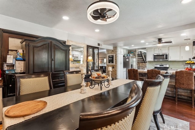 dining space with recessed lighting, a ceiling fan, a textured ceiling, wood finished floors, and stairs