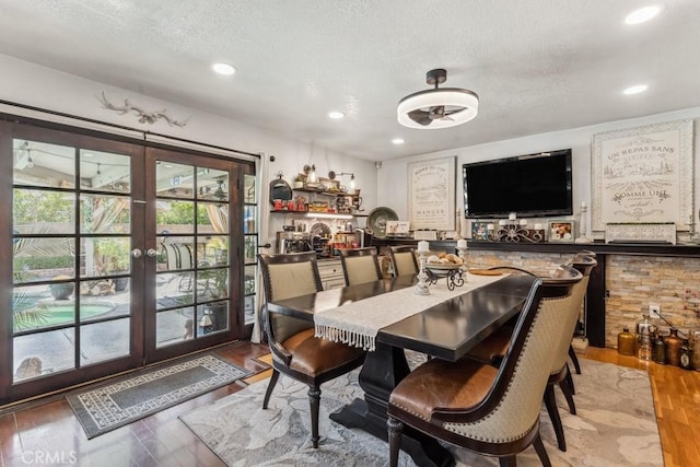 dining room with recessed lighting, french doors, light wood-style flooring, and a textured ceiling