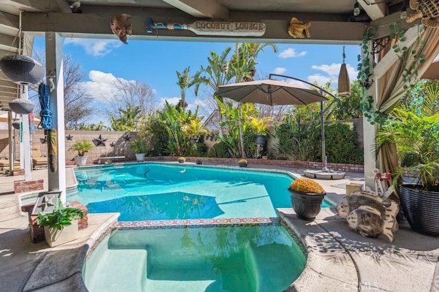 view of swimming pool featuring a patio, a fenced backyard, and a pool with connected hot tub