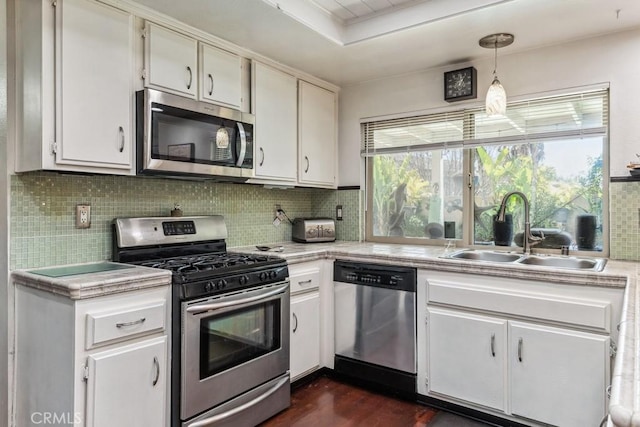 kitchen with stainless steel appliances, a wealth of natural light, a sink, and light countertops