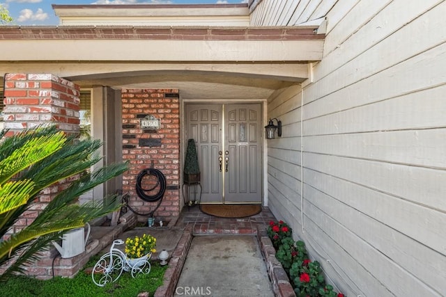 entrance to property featuring brick siding