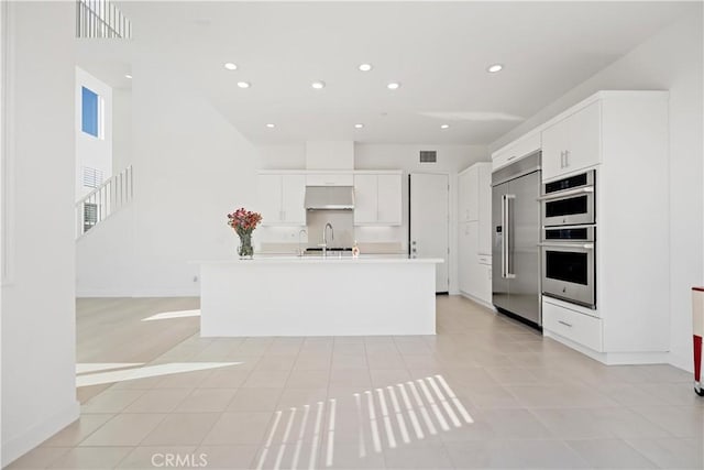 kitchen with light countertops, visible vents, appliances with stainless steel finishes, white cabinets, and a sink