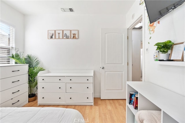 bedroom with light wood finished floors and visible vents