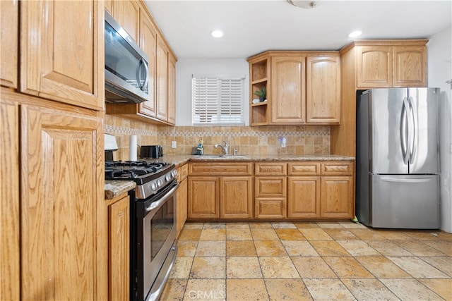 kitchen featuring a sink, appliances with stainless steel finishes, open shelves, tasteful backsplash, and stone tile flooring