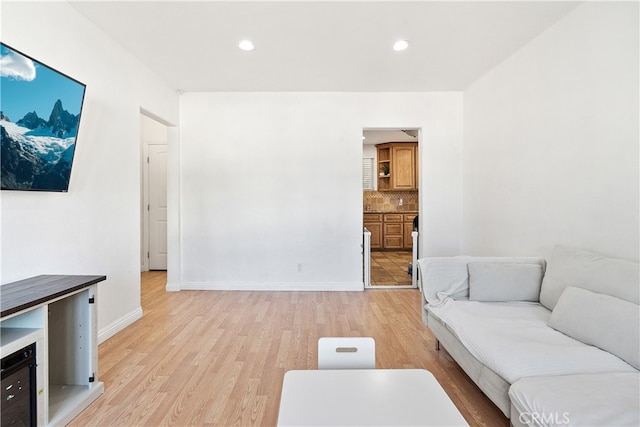 living room with light wood-type flooring, baseboards, and recessed lighting