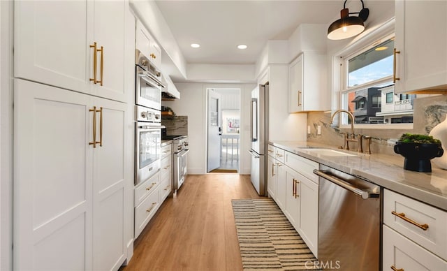 207 E Edgewater Ave Unit A, Newport Beach, CA 92661 - kitchen with white cabinets, a sink, light wood-type flooring, recessed lighting, and appliances with stainless steel finishes