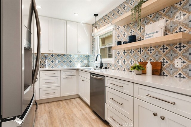 207 E Edgewater Ave Unit A, Newport Beach, CA 92661 - kitchen featuring stainless steel appliances, backsplash, light countertops, a sink, and white cabinetry