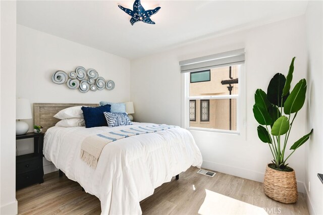 207 E Edgewater Ave Unit A, Newport Beach, CA 92661 - bedroom featuring baseboards, wood finished floors, and visible vents