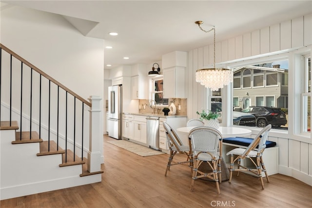 207 E Edgewater Ave Unit A, Newport Beach, CA 92661 - dining space featuring recessed lighting, an inviting chandelier, stairs, and light wood-type flooring
