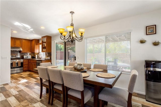 dining room with recessed lighting, baseboards, and an inviting chandelier