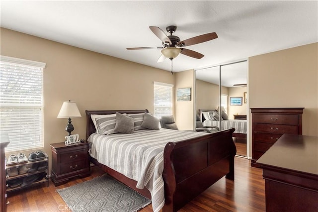 bedroom featuring dark wood-style floors, a ceiling fan, and a closet