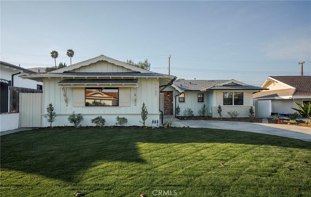 ranch-style home featuring a front lawn, board and batten siding, and fence