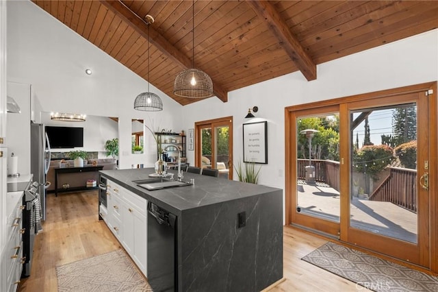 kitchen featuring stainless steel appliances, a sink, white cabinets, beam ceiling, and dark countertops