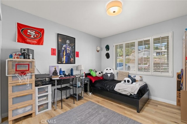 bedroom with baseboards and wood finished floors