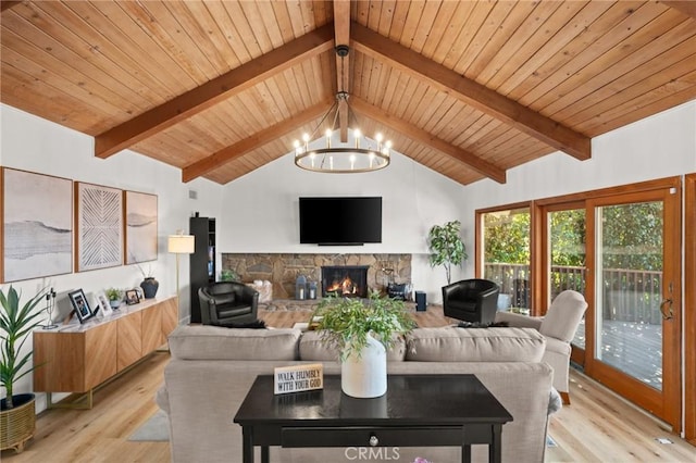 living room with vaulted ceiling with beams, light wood-style flooring, a fireplace, wood ceiling, and an inviting chandelier